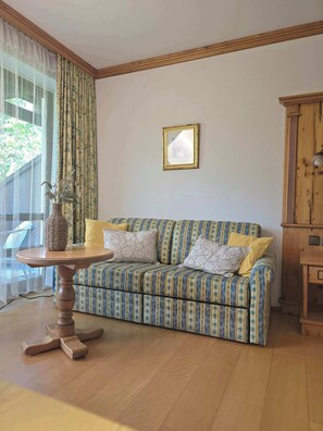 Ein Wohnzimmer mit einer Couch, einem Tisch und einem Schrank.