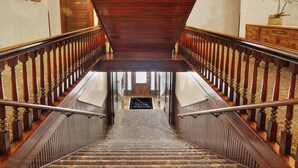 A grand staircase with ornate railings and carpeted steps leading to a landing. - Downtown Palace Hotel Suite - Steps to Adventure (Salida)