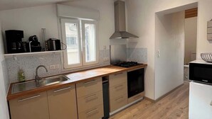 Una cocina moderna con una isla central, horno empotrado y una ventana sobre el lavabo.