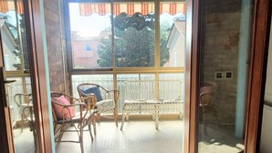 Ein Balkon mit Korbmöbeln und Blick auf Gebäude.