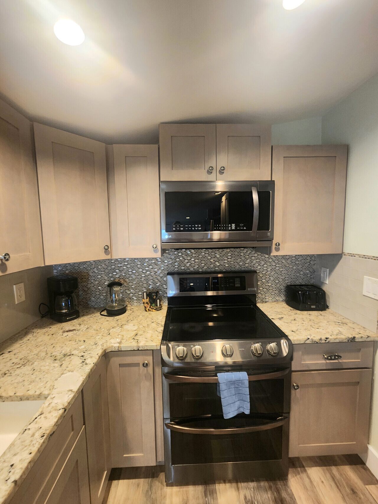 A kitchen with a stove, oven, microwave, and coffee maker.
