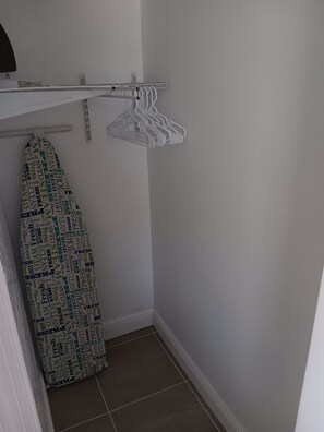 A small laundry area with a hanging rack and an ironing board. - Villa Paris apartment#2 close to airport, hospital, stadium, market, store (Tampa)