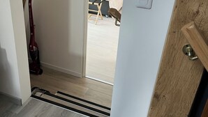 Un couloir menant à une chambre à coucher équipée d’un lit, d’un bureau et d’une chaise.