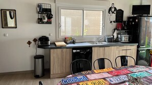 Une cuisine de taille réduite, dotée d’une fenêtre, d’un évier, d’une cuisinière et d’un réfrigérateur.