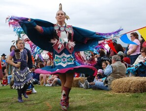 Une personne vêtue d’un costume traditionnel se produit devant un public.