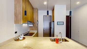 Una cocina moderna con encimera de granito, pileta de acero inoxidable y muebles de madera.
