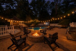 An outdoor patio with a pool, fire pit, and seating area. - Backyard Resort, Pool, Arcade & Fire Pit (Amherst)