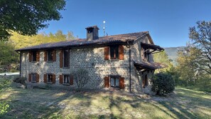 Ein Steinhaus mit Ziegeldach, Holzhörnchen und Schornstein.