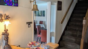 A wooden reception desk with a clock, a statue, and various items on it. - Mayfair Hotel (Skegness)