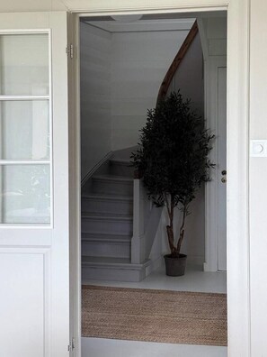 A staircase with a potted plant at the bottom. - Family home with fairytale garden in Talgje (Rogaland)