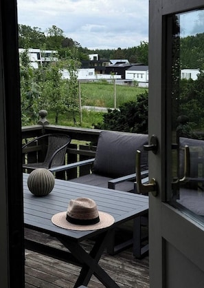 A wooden deck with a table, chairs, and a hat. - Family home with fairytale garden in Talgje (Rogaland)