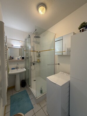 Ein modernes Badezimmer mit einer Duschkabine, einem Waschbecken und einer Toilette.