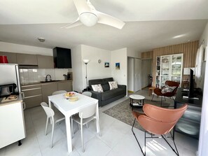 Eine moderne Küche mit Essbereich, einer Couch und einem Fernseher im Wohnzimmer.