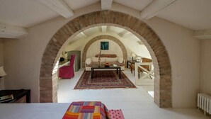 An arched room with a sofa, coffee table, and patterned rug. - Elegant Castello Retreat with Terrace Near Biennale & San Marco (Venezia)