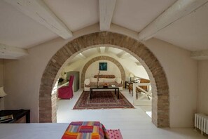 An arched room with a sofa, coffee table, and patterned rug. - Elegant Castello Retreat with Terrace Near Biennale & San Marco (Venezia)