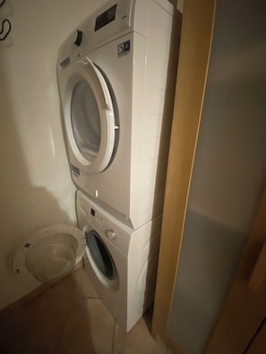 Una bugaderia petita amb dues rentadora superposades i una assecadora.