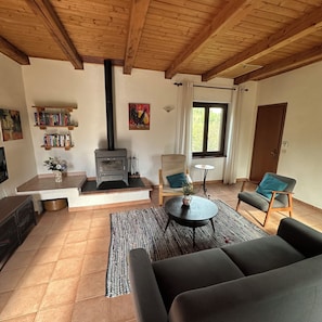 A cozy living room with a fireplace, comfortable seating, and a bookshelf.