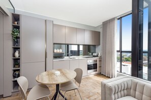 Eine moderne Küche mit Essbereich, großen Fenstern und Blick auf die Stadt.