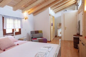 A bedroom with a bed, bedside table, lamp, window with curtains, and a chair. - Perfect Escape Luxurious Villa Anastasia Tranquil Retreat in Arkadades Greece (Corfu)