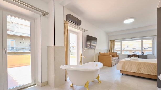 Un baño moderno con una bañera independiente, ducha e inodoro.