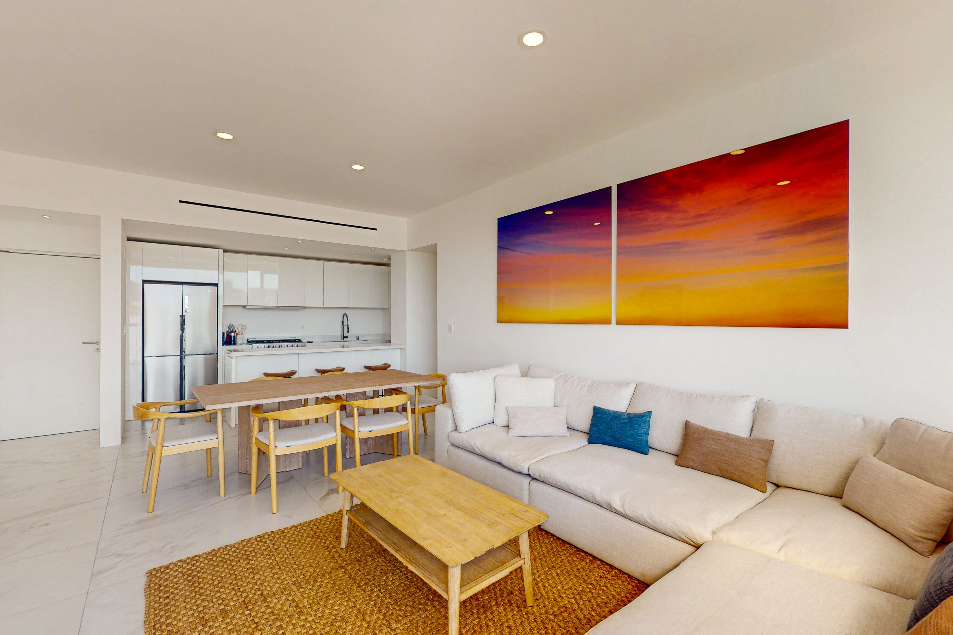 Uma sala de estar moderna com sofá, mesa de centro e área de jantar.