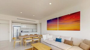 Una sala de estar moderna con sofá, mesa de centro y comedor.