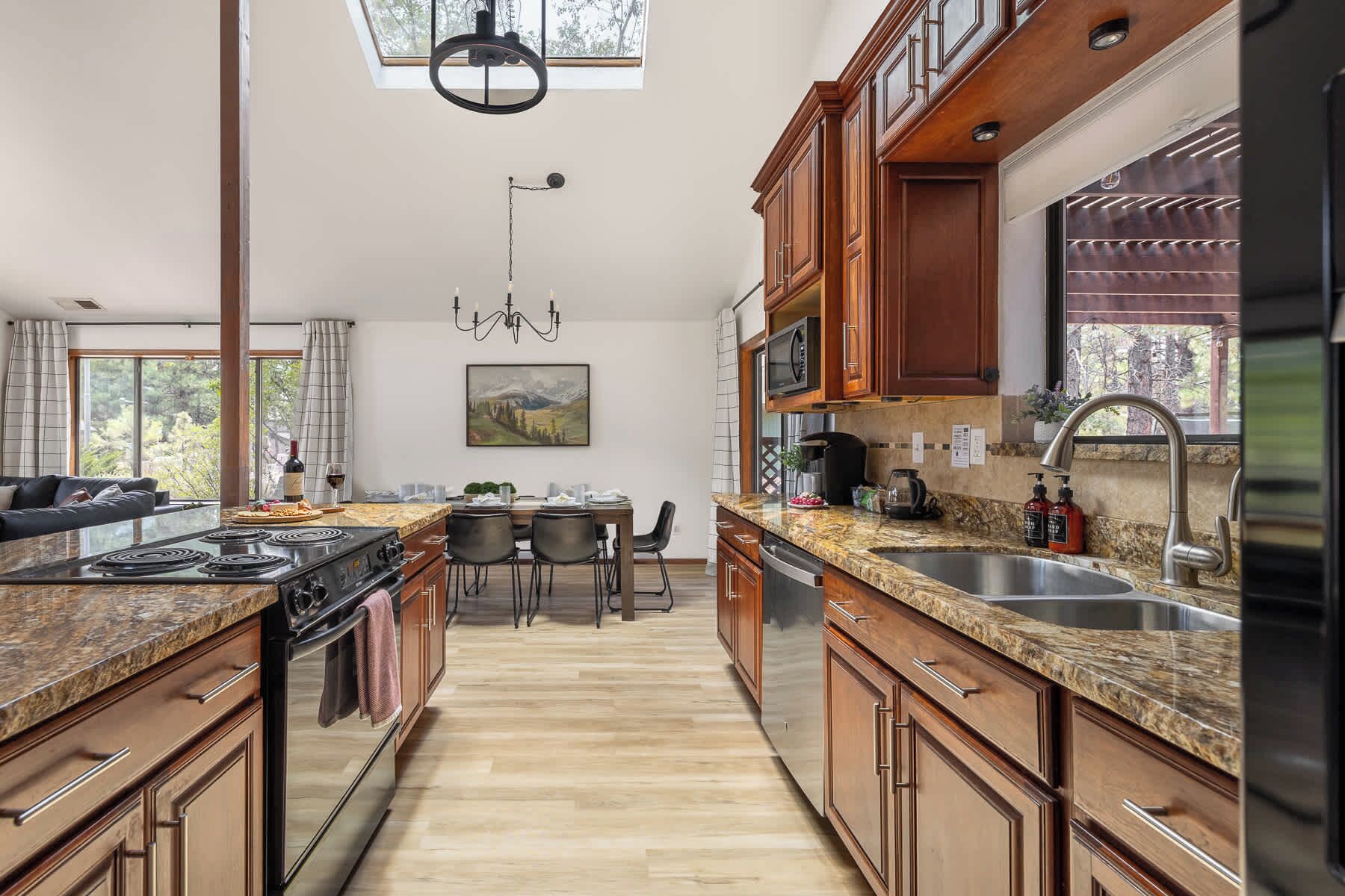 A modern kitchen with granite countertops, stainless steel appliances, and wooden cabinets.