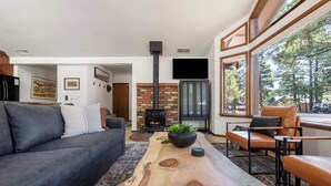 Ein modernes Wohnzimmer mit Kamin, Ledermöbeln und großen Fenstern.