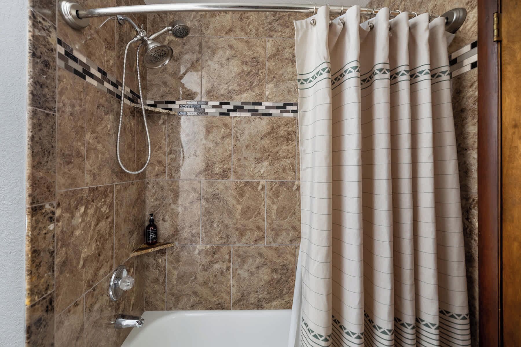 Une salle de bain avec une douche, une baignoire et un porte-serviettes.