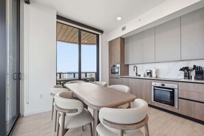 Una cocina moderna con comedor, ventanas amplias y vistas a la ciudad.