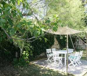 An outdoor patio with a table and chairs, surrounded by greenery and a pergola. - Apartment 'La Roseraie Des Côtes' with Private Pool, Private Garden and Wi-Fi (Vinsobres)