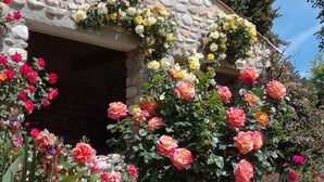 Un edificio de piedra con un jardín lleno de rosas.