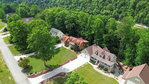 A residential area with multiple houses, a driveway, and a well-maintained lawn. - Welcome to "Sheltowee Shores"- Lake Cumberland Views & Lake Trail (Burnside)