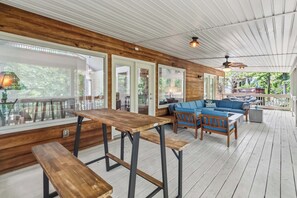 A wooden deck with outdoor seating, including benches and a sofa, and large windows offering views of the outdoors. - Welcome to "Sheltowee Shores"- Lake Cumberland Views & Lake Trail (Burnside)