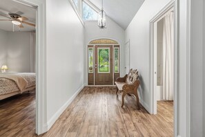 A hallway with wooden flooring, a bed with a patterned bedspread, a ceiling fan, and a chandelier. - Welcome to "Sheltowee Shores"- Lake Cumberland Views & Lake Trail (Burnside)