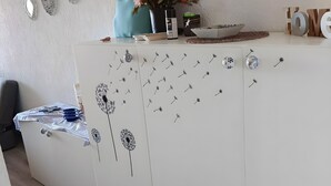 Un comptoir d’accueil agrémenté d’un arrangement floral, d’un vase et d’assiettes décoratives.
