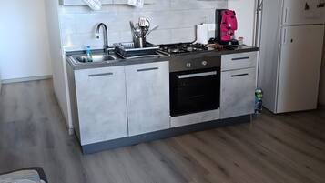 Een koelkast, een oven, een kookplaat, een koffiezetapparaat/waterkoker