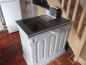 Eine Küche mit einem weißen Kühlschrank, einem Toaster und einer Kaffeemaschine auf der Arbeitsfläche.