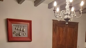 Ein Wohnzimmer mit einem dunklen Sofa, einem roten Tisch, einer Kronleuchter und einem Holzschrank.