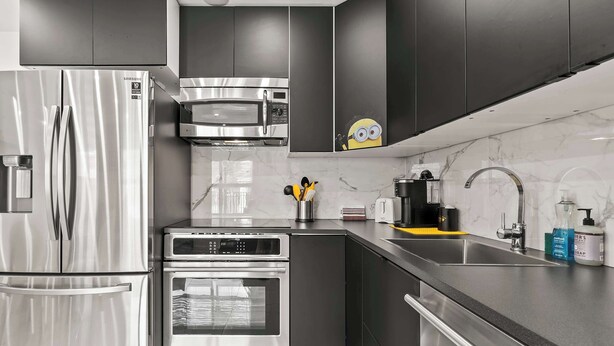 Una cocina moderna con electrodomésticos de acero inoxidable, un microondas y un lavabo.