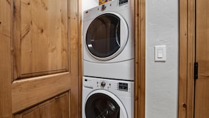 Lavadora y secadora apiladas en un mueble de madera.