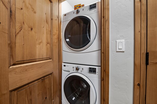 Eine gestapelte Waschmaschine und ein Trockner in einem Holeschrank.