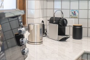 A kitchen with a coffee maker, a kettle, and a jar on the counter. - Holiday Home 'Villino Rosaria Sea View' with Sea View, Wi-Fi and Air Conditioning (Dragonea)