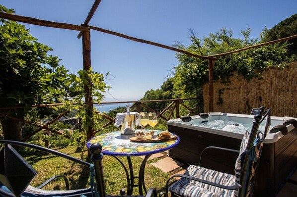 Ein Whirlpool, Sitzgelegenheiten im Freien und ein Tisch mit Speisen und Getränken in einem Garten.