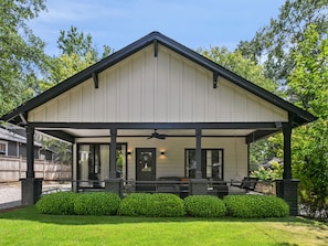 A covered porch with a black roof, a door, and a window. - FIFA 2026 HQ - Two Cabins, Sleeps 12 - 2.5 Mi to Mercedes-Benz Stadium (Atlanta)