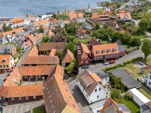 An aerial view of a coastal town with traditional architecture, including red-roofed houses and a prominent church. - 4 Star Holiday Home in Allinge (Allinge)