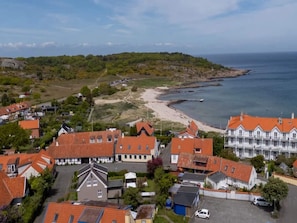 A coastal village with traditional red-roofed houses, a beach, and a large white building with multiple windows. - 4 Star Holiday Home in Allinge (Allinge)