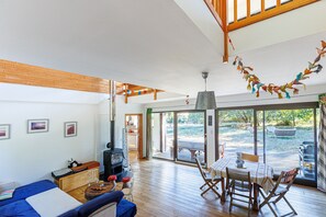 A spacious living area with a sofa, a dining table, and a fireplace.
