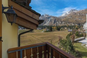 Ein Holzbalkon mit Blick auf eine gebirgige Landschaft.