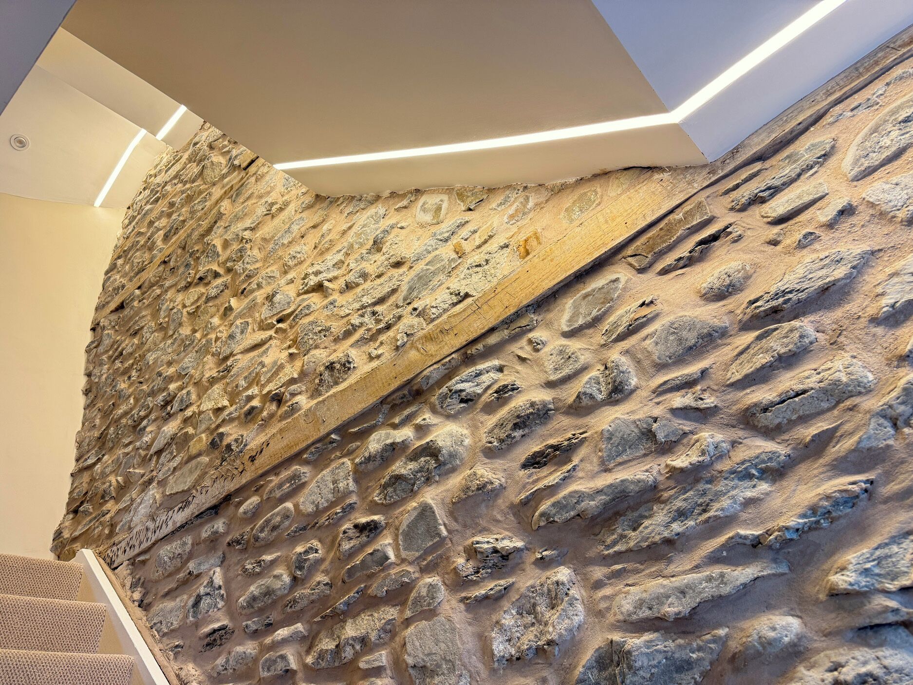 A textured stone wall with a modern light fixture.
